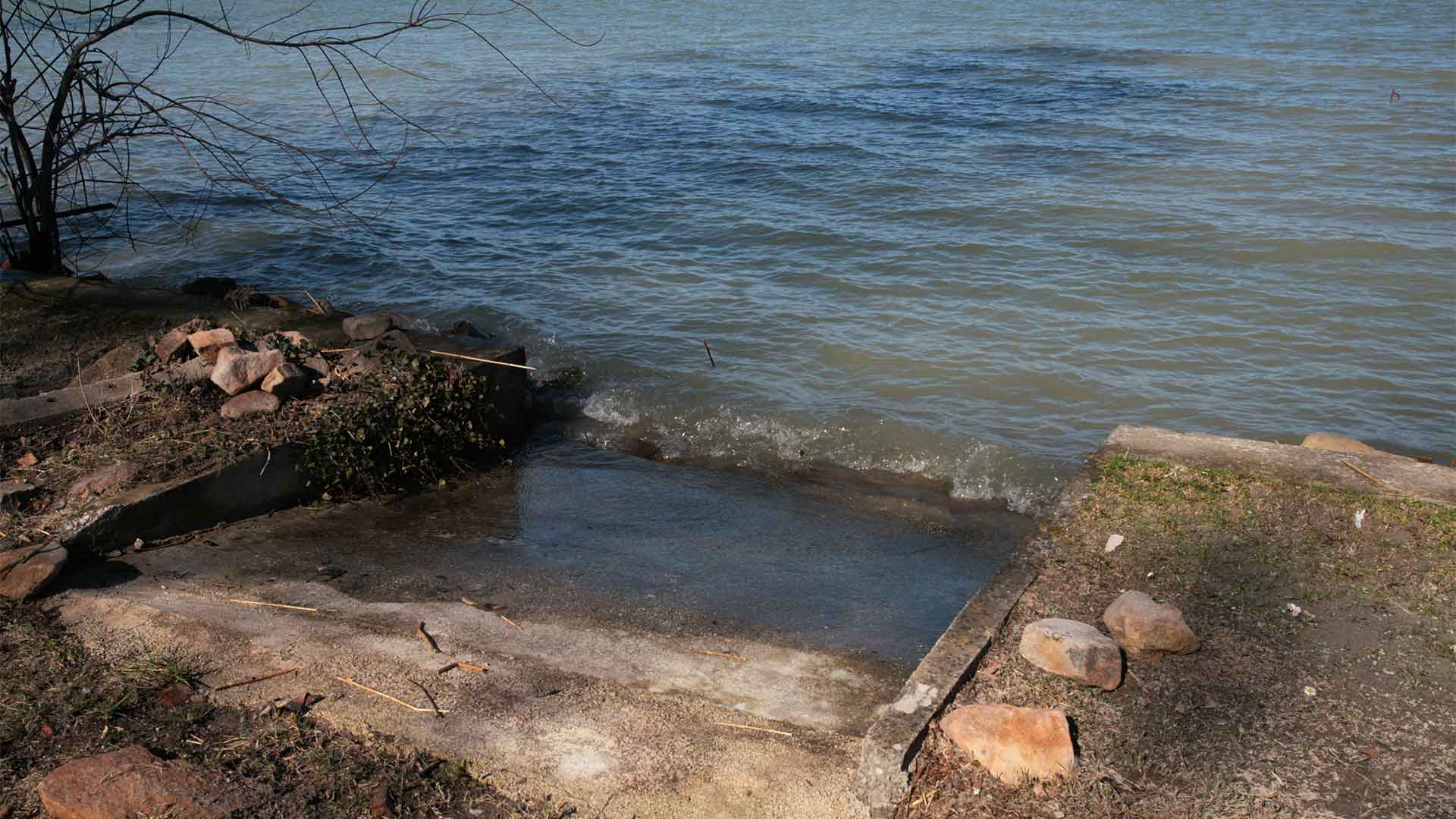 A képen, egy csónak és/vagy kistestű vitorlás leengedő sólya látható egy közvetlen vízparti ingatlannál a Balaton déli partján.